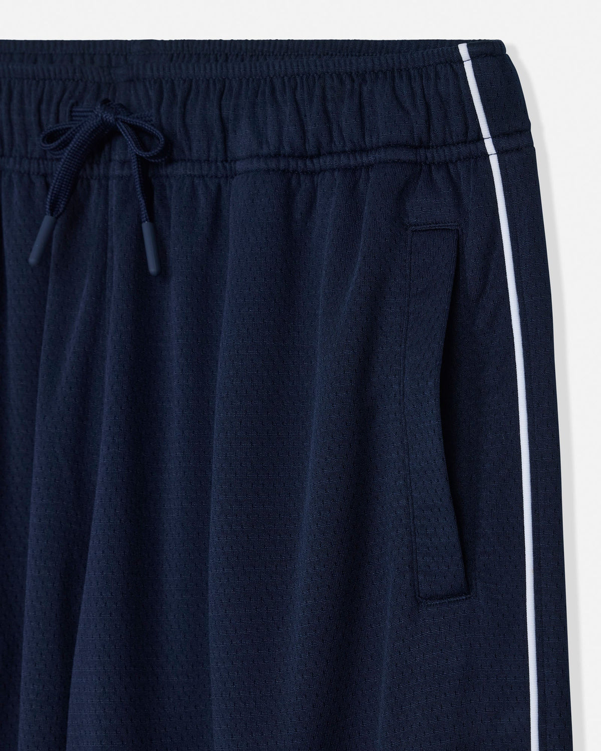 Close-up of navy blue athletic pants with a white side stripe, elastic waistband, and drawstring.