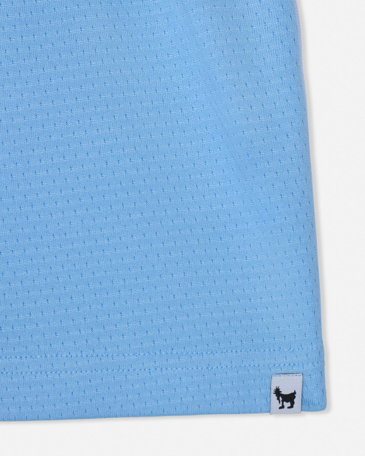 Close-up of a blue textured fabric with a brand label on a white background