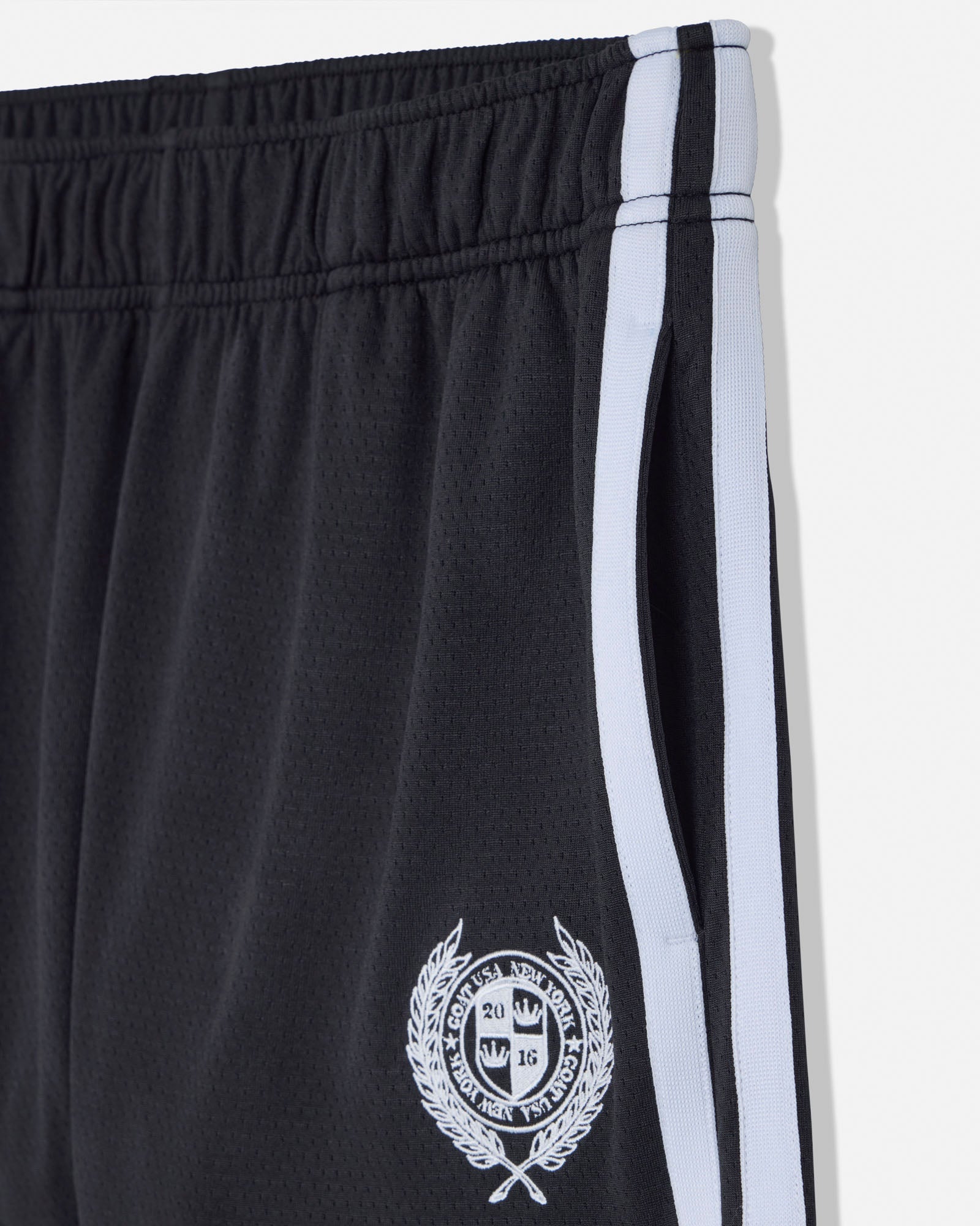 Black shorts with a white stripe and emblem on a white background#color_black