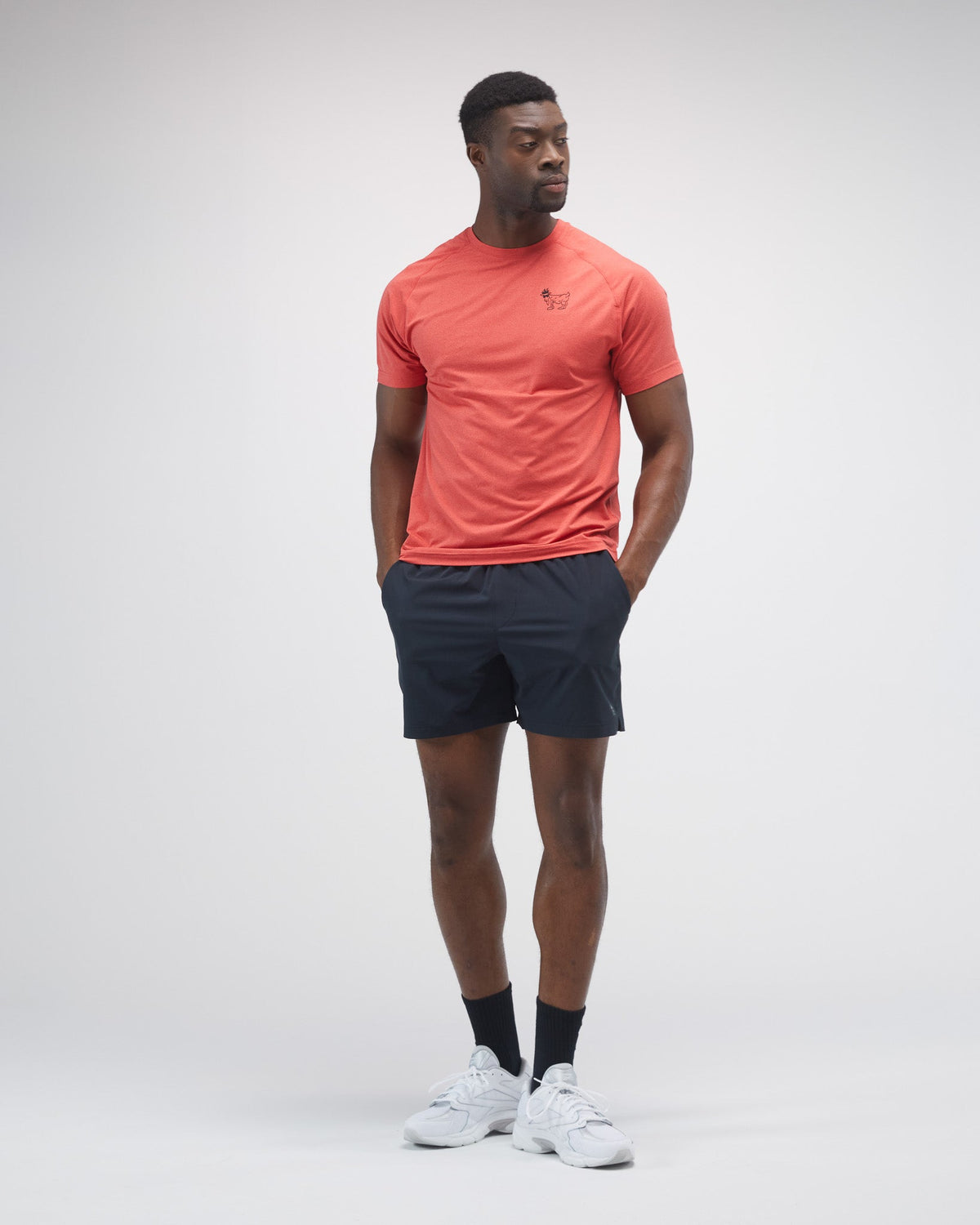 Man wearing a poinsettia t-shirt and black shorts on a white background