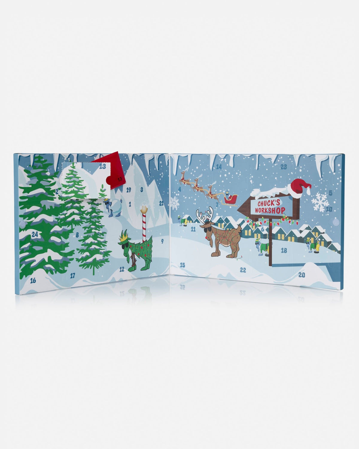 A Christmas advent calendar spread open to show multiple illustrated doors with snowy winter scenes, evergreen trees, a reindeer, Santa, and a sign reading 'Chuck's Workshop'.
