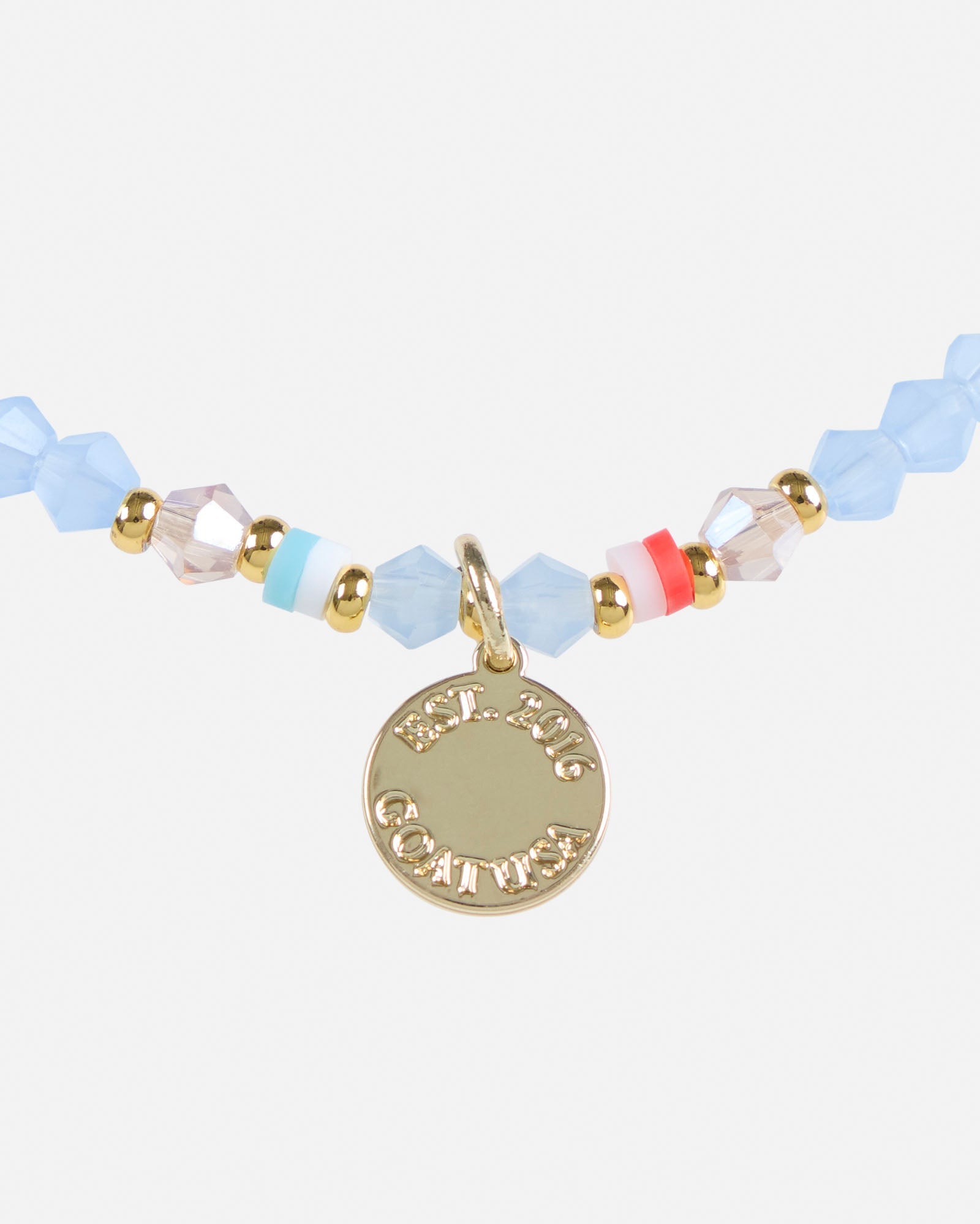 Bracelet with colorful beads and a gold charm on a white background