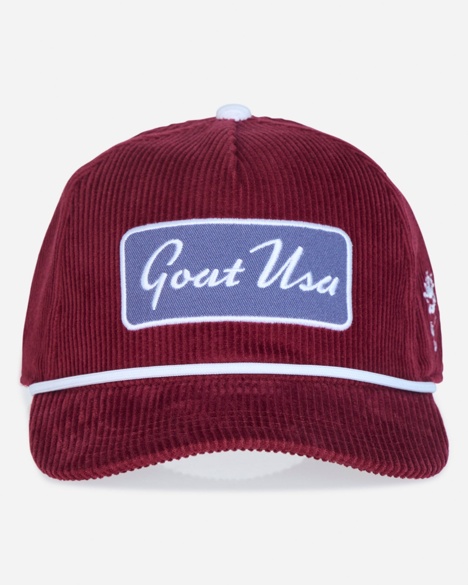 A burgundy corduroy baseball cap with a white embroidered 'Goat USA' patch on the front, a white stripe across the brim, and a small embroidered logo on the side, shown against a light gray background.