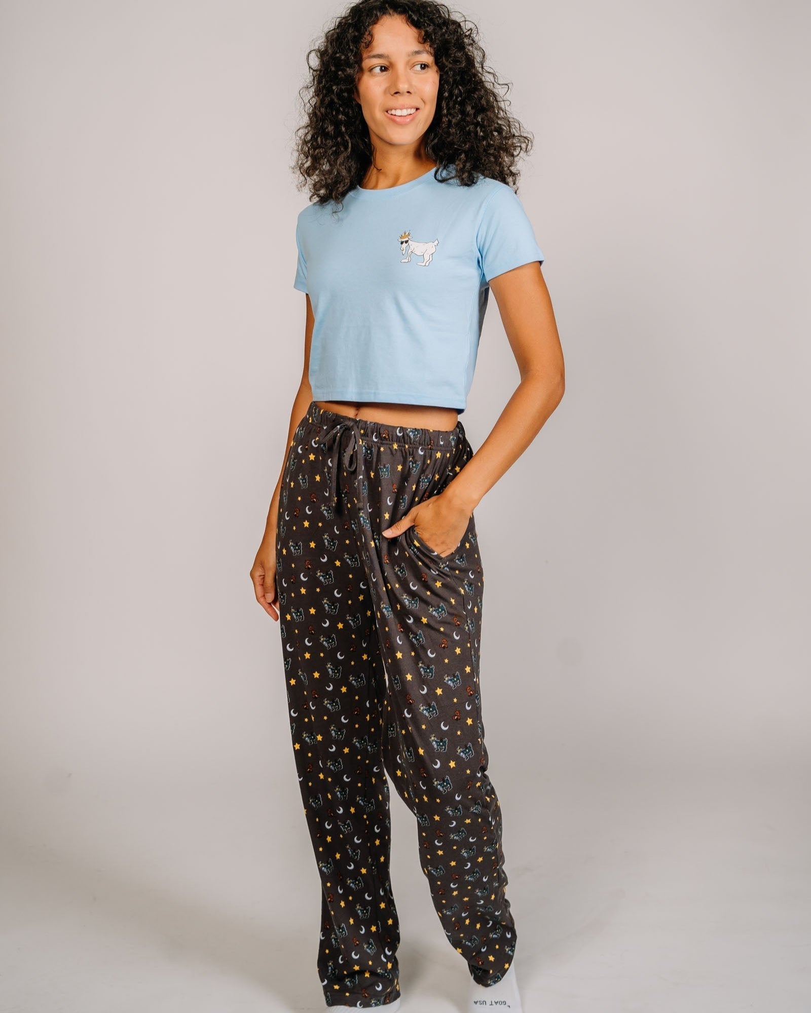 Female model wearing pajama pants with goats, teddy bears, stars and moons