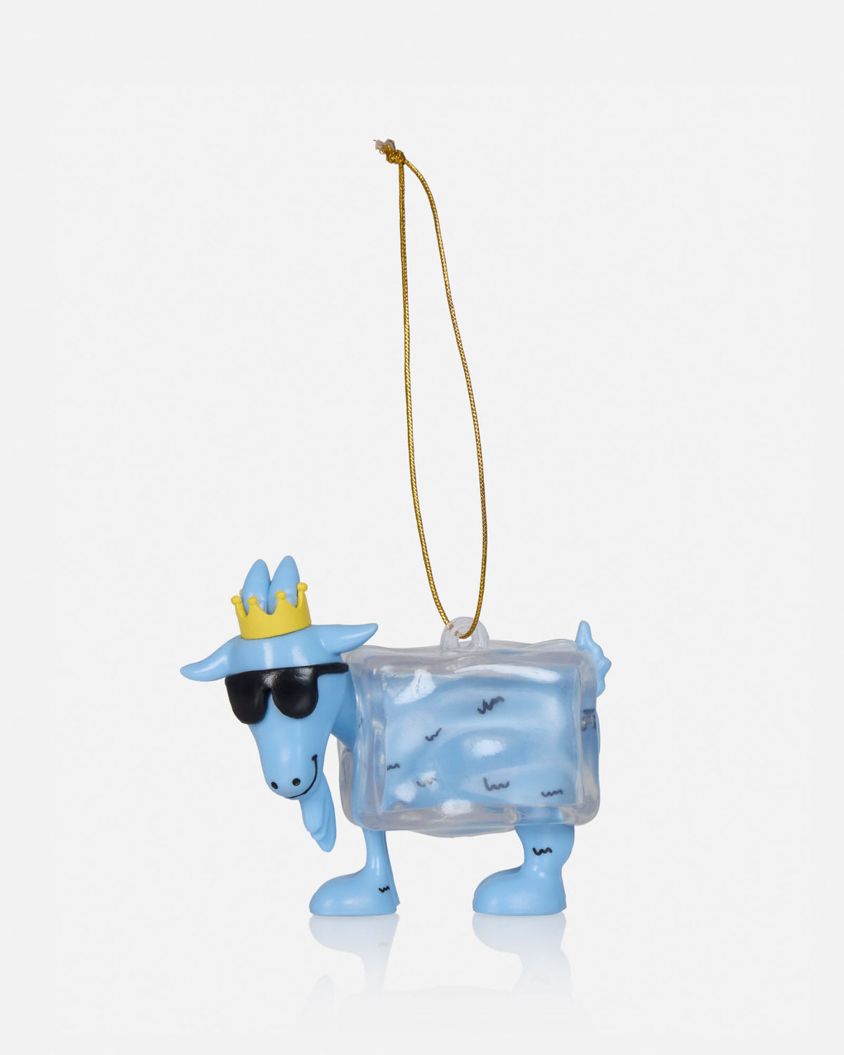 A light blue goat-shaped Christmas ornament wearing a yellow crown and black sunglasses, with a clear ice-box body containing small black snowflake details, complete with a gold hanging string, on a light gray background.