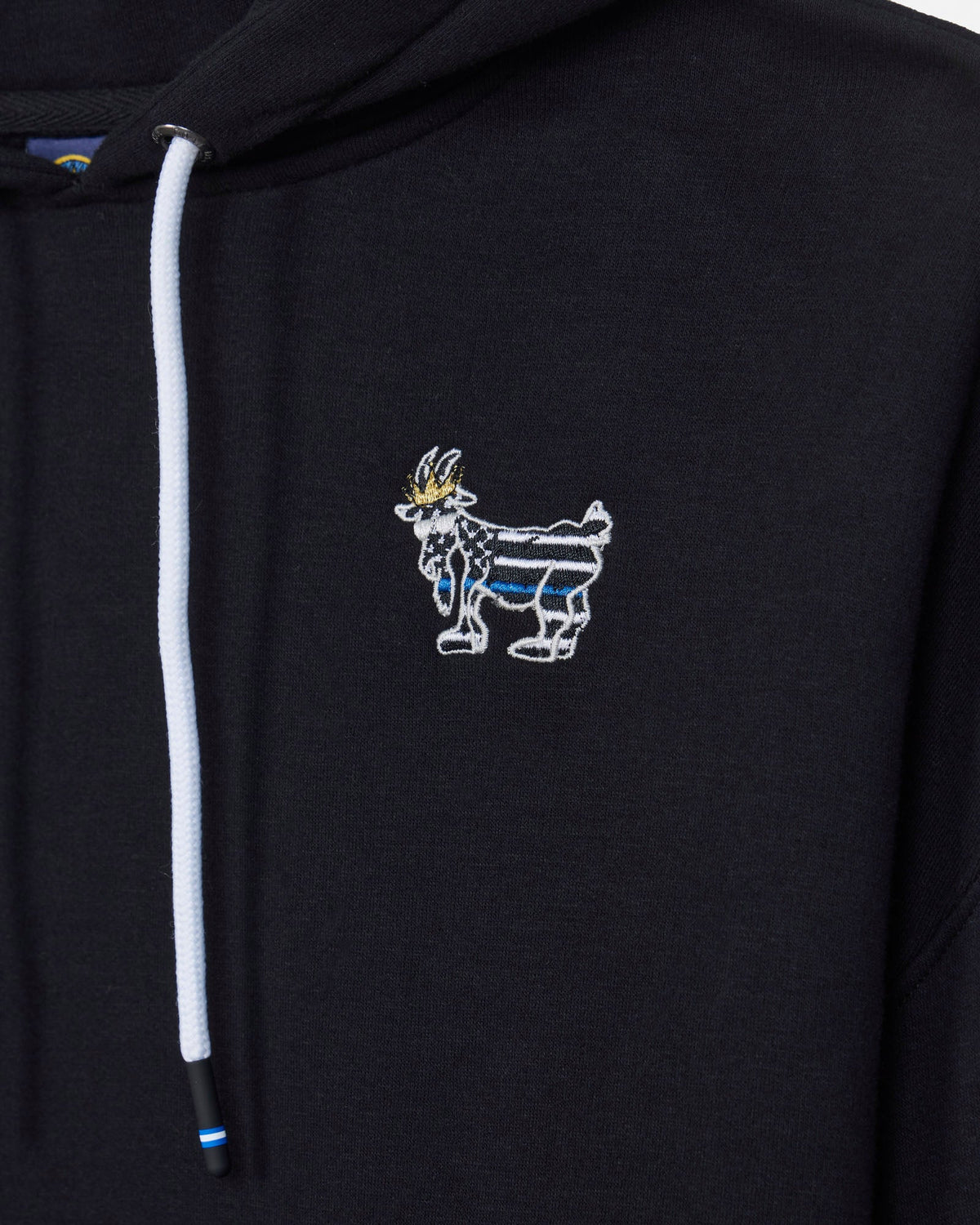 Close-up of a black hoodie featuring a white drawstring and a small embroidered goat mascot logo on the left chest, with blue and gold details.