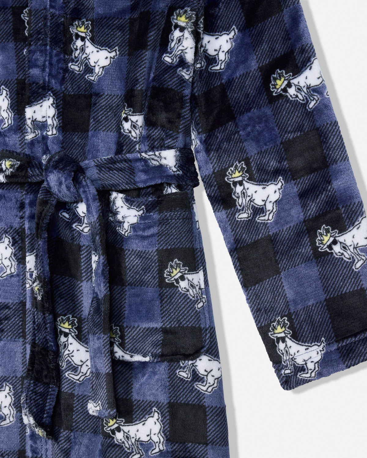 Close-up of a plush long-sleeve robe in a navy and black buffalo plaid pattern, featuring a repeating print of white cartoon goats wearing small gold crowns, with a matching tie belt.