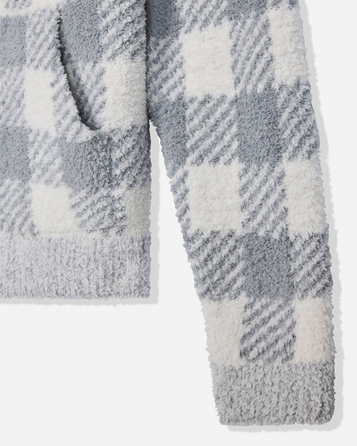 Close-up of a plush fleece garment with a gray and off-white check pattern, showing the soft texture and ribbed trim on a white background.
