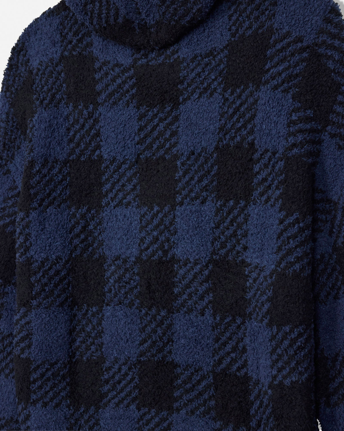 Close-up of a plush fleece hoodie in a navy and black buffalo plaid pattern.