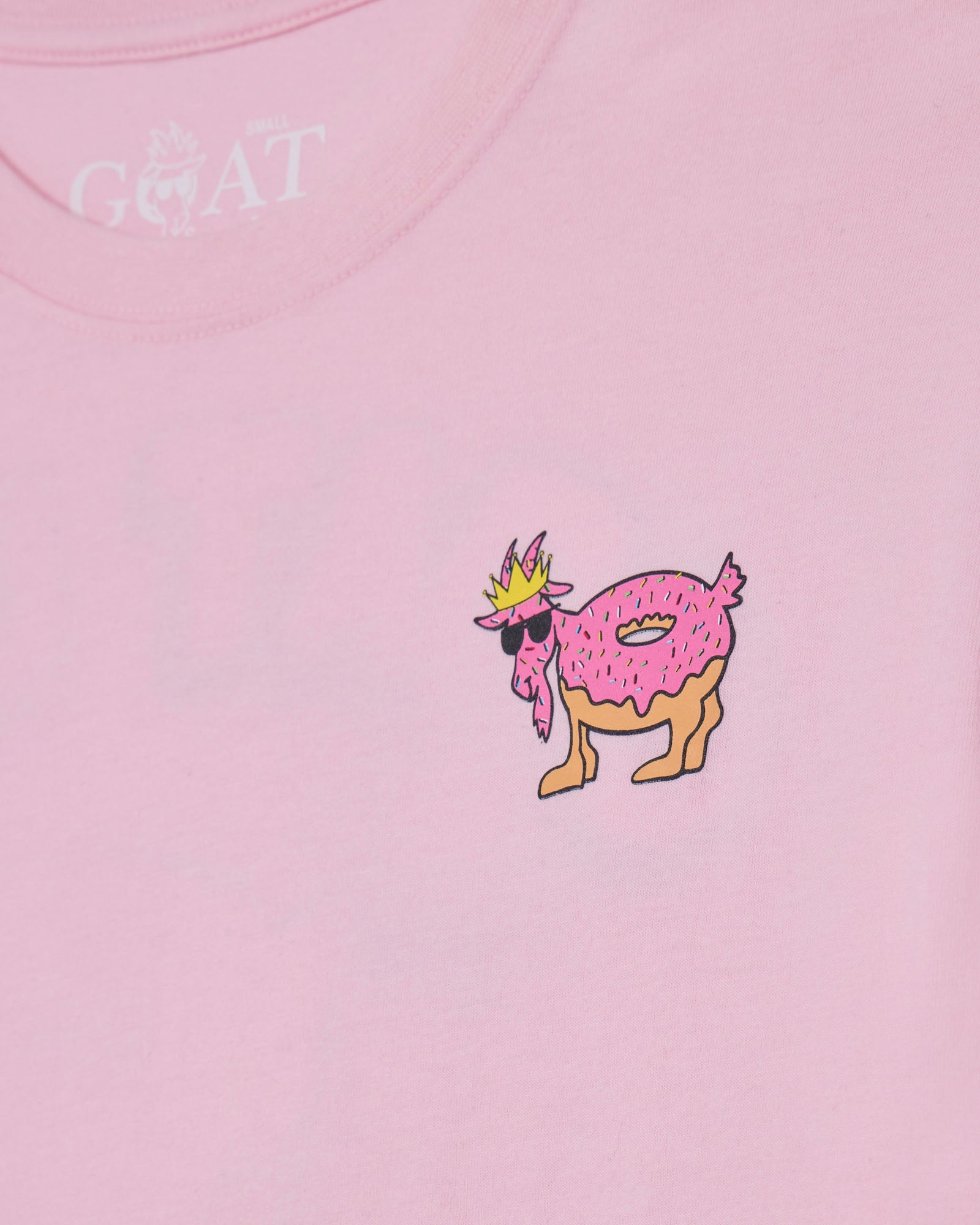 Pink t-shirt with a cartoon goat wearing a crown and sunglasses, and the brand 'GOAT USA' on a pink background.