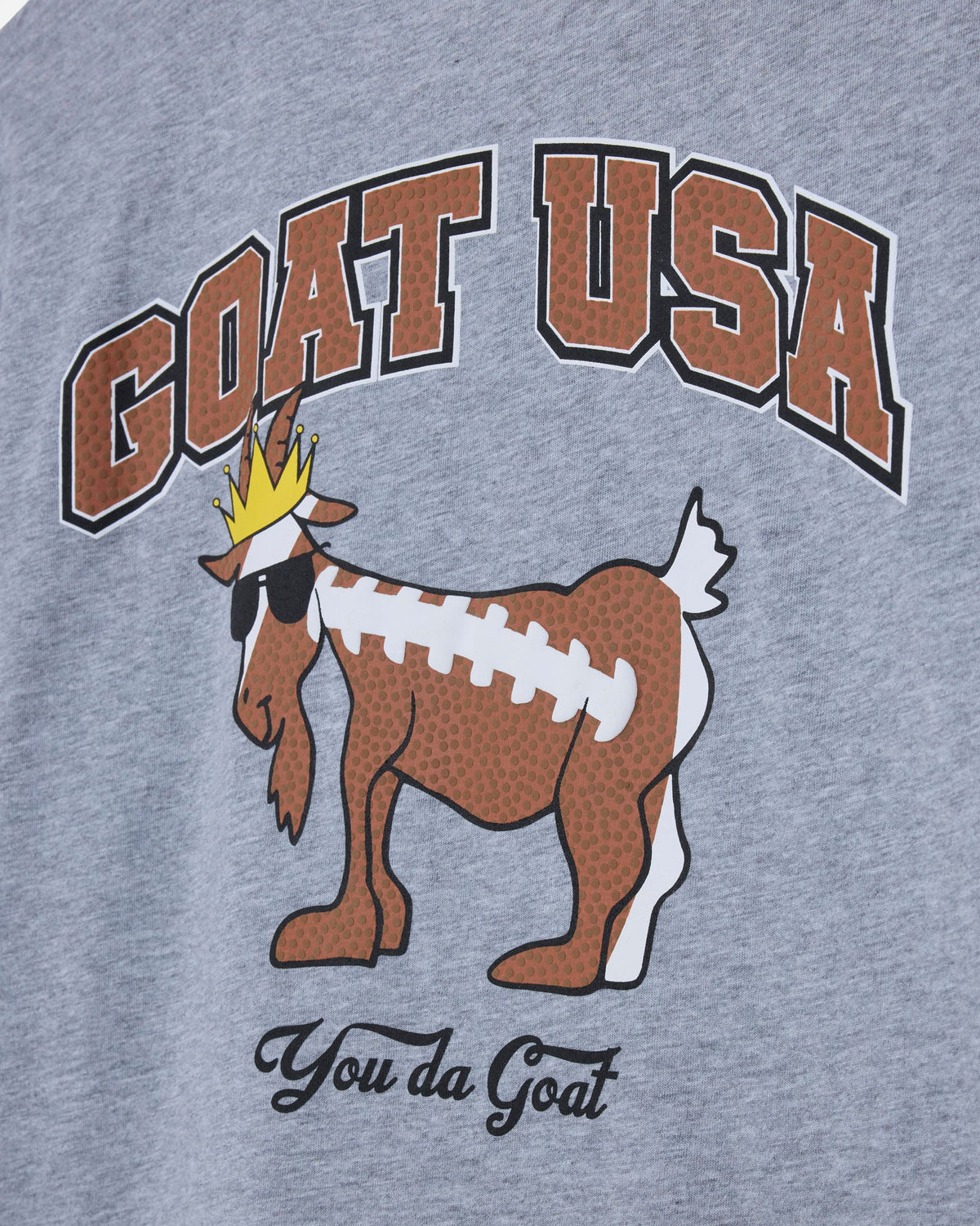 Gray t-shirt with 'GOAT USA' and a cartoon goat design on a plain background