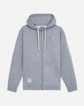 A light gray heather zip-up hoodie with white drawstrings, featuring a small embroidered blue goat on the left chest and a circular embroidered patch on the right sleeve, displayed against a clean off-white background.