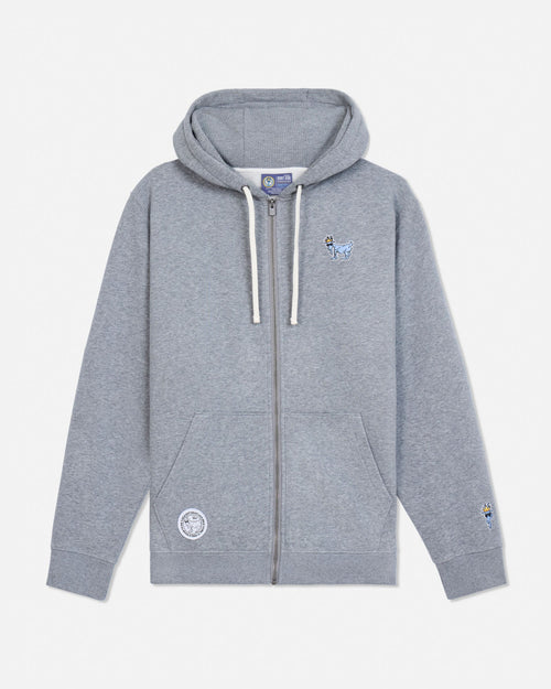 A light gray heather zip-up hoodie with white drawstrings, featuring a small embroidered blue goat on the left chest and a circular embroidered patch on the right sleeve, displayed against a clean off-white background.