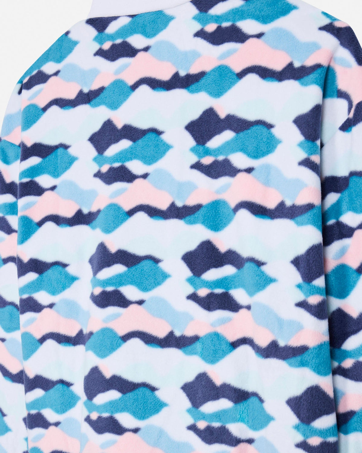 Close-up of a fleece garment with an abstract wavy pattern in light blue, teal, pink, and dark navy on a pale background.