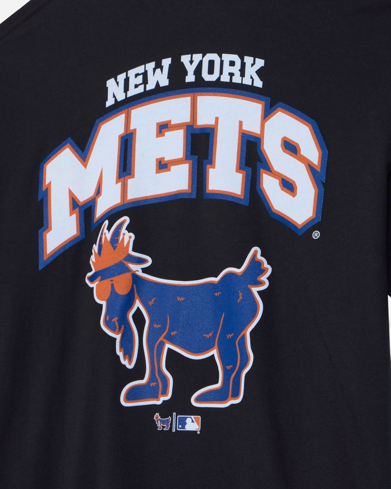 Close-up of a black New York Mets graphic T-shirt featuring the team name in white with blue and orange outlines, plus the blue goat logo below.