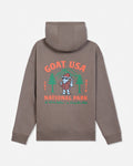 A brownish-gray pullover hoodie shown from the back, featuring a colorful graphic print with the text 'GOAT USA NATIONAL PARK' and an illustration of a cartoon goat in a hat with pine trees.