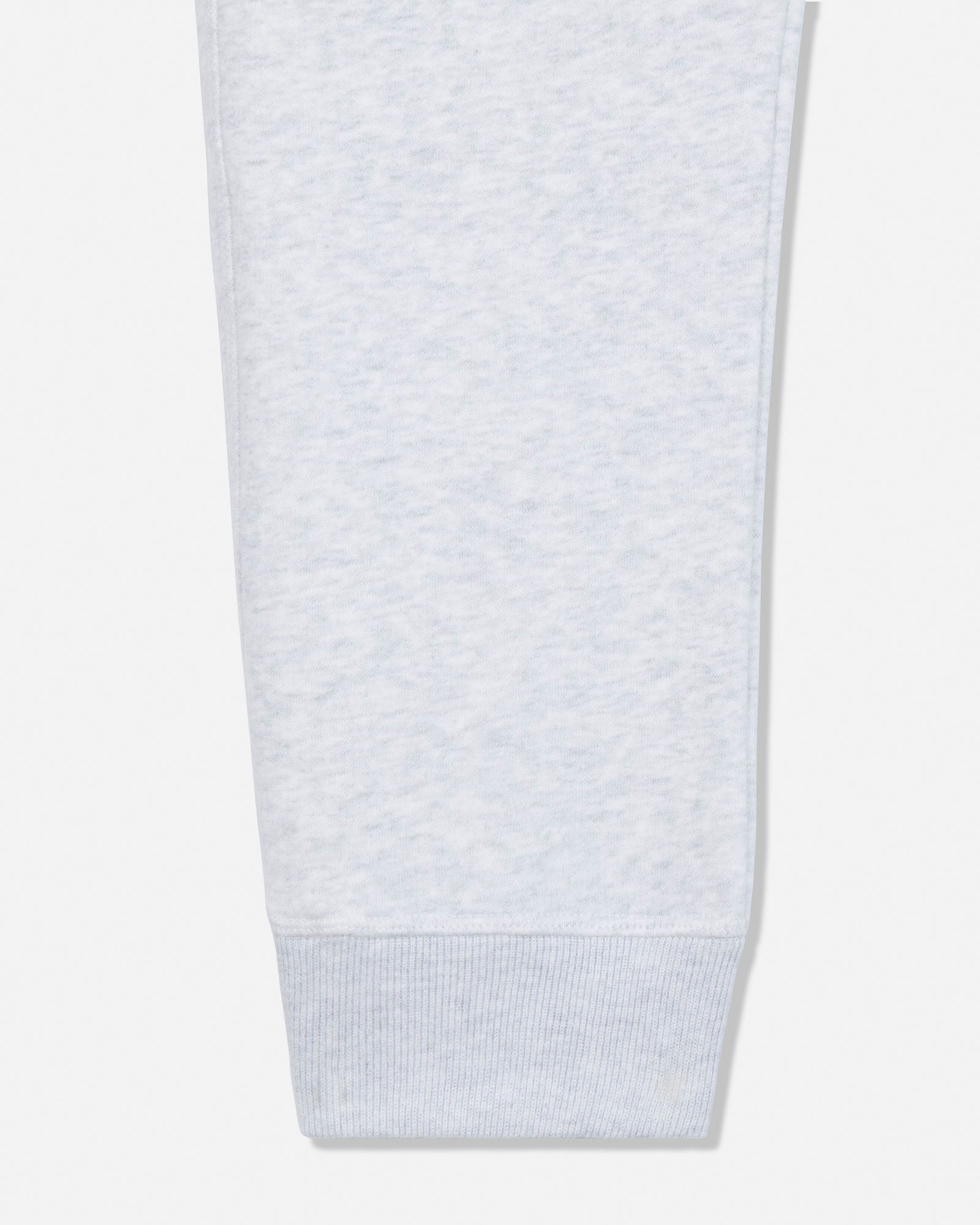 Close-up of a light heather gray fabric sleeve or cuff with a ribbed knit bottom hem, shown against a plain light gray background.#color_pale-gray