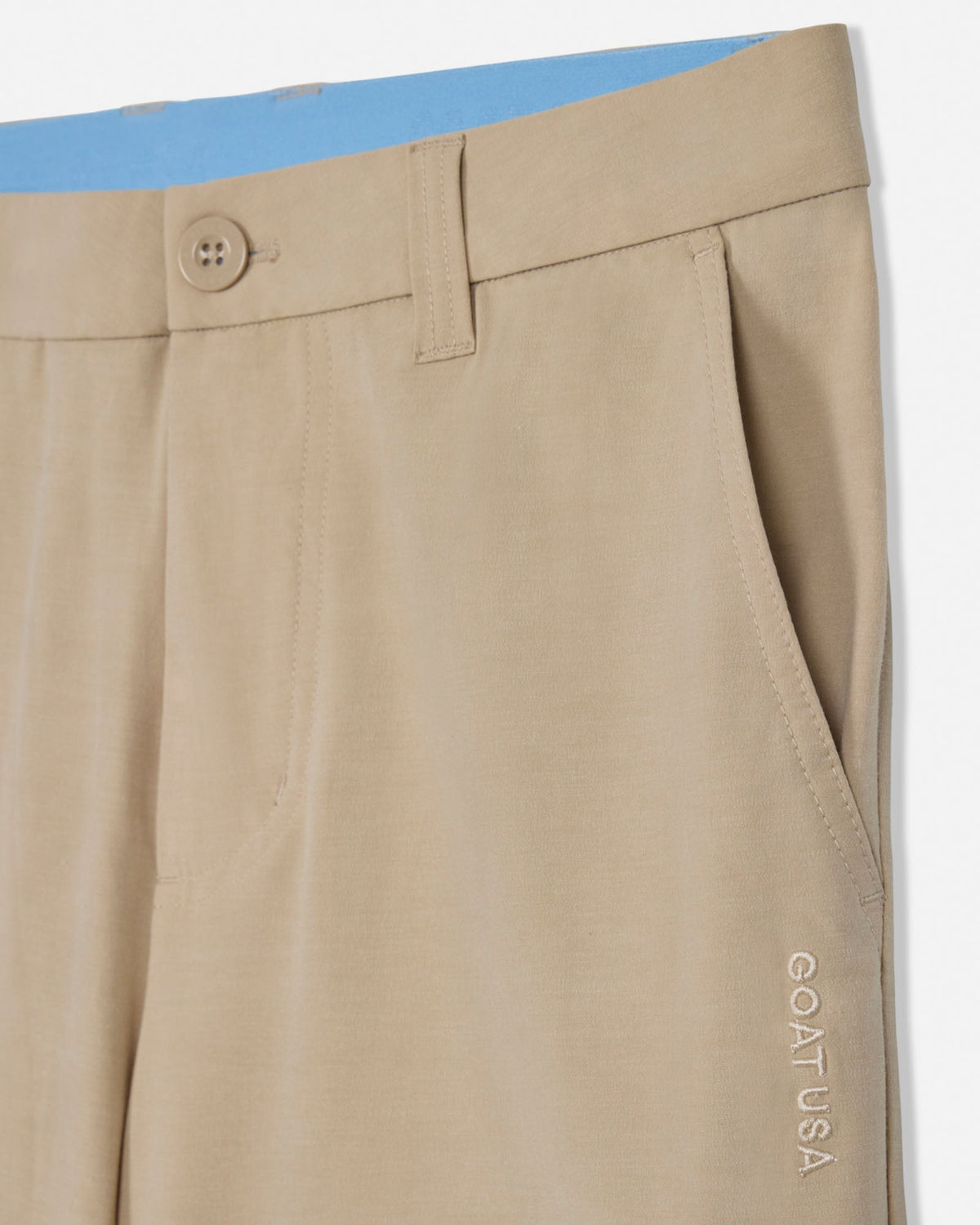 Beige pants with a button and 'GOAT USA' branding on a white background
