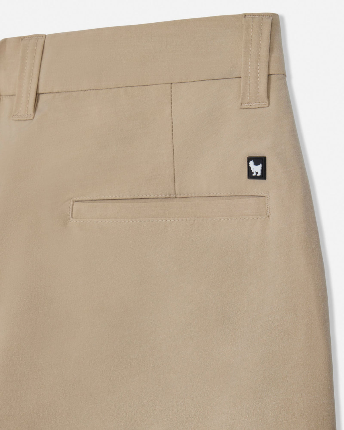 Beige pants with a small logo on the pocket against a white background