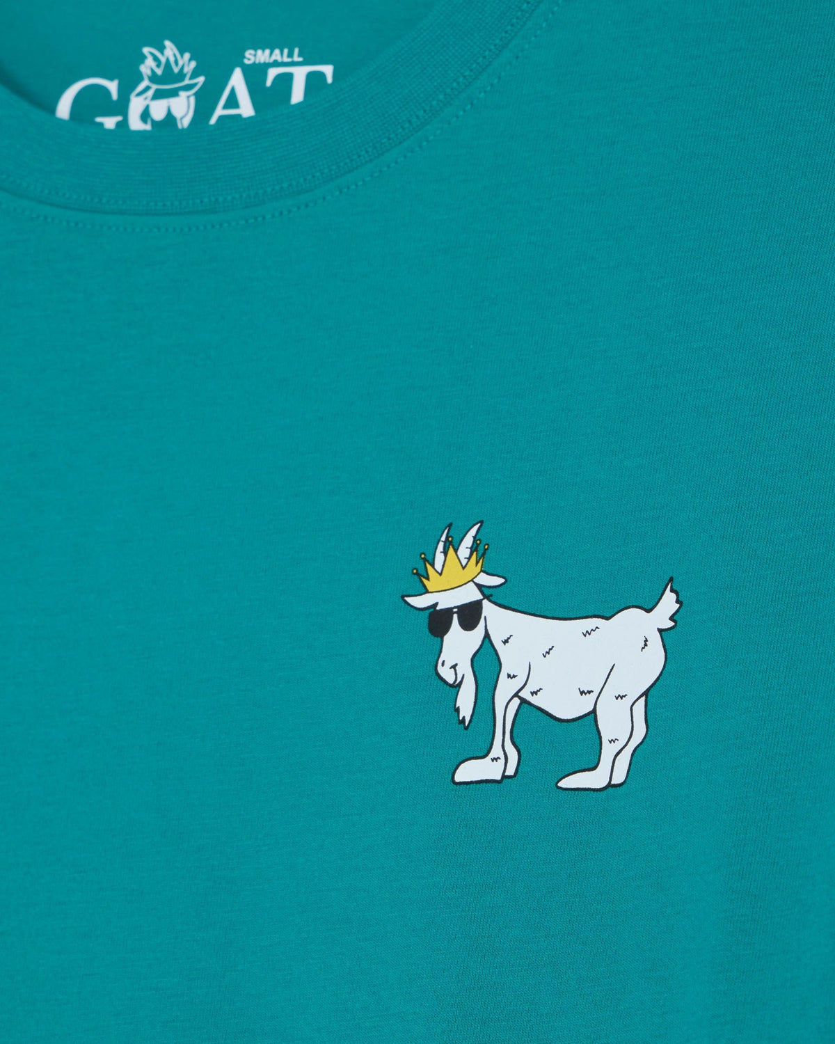 Teal t-shirt with a white cartoon goat wearing a crown and sunglasses on a blue background.