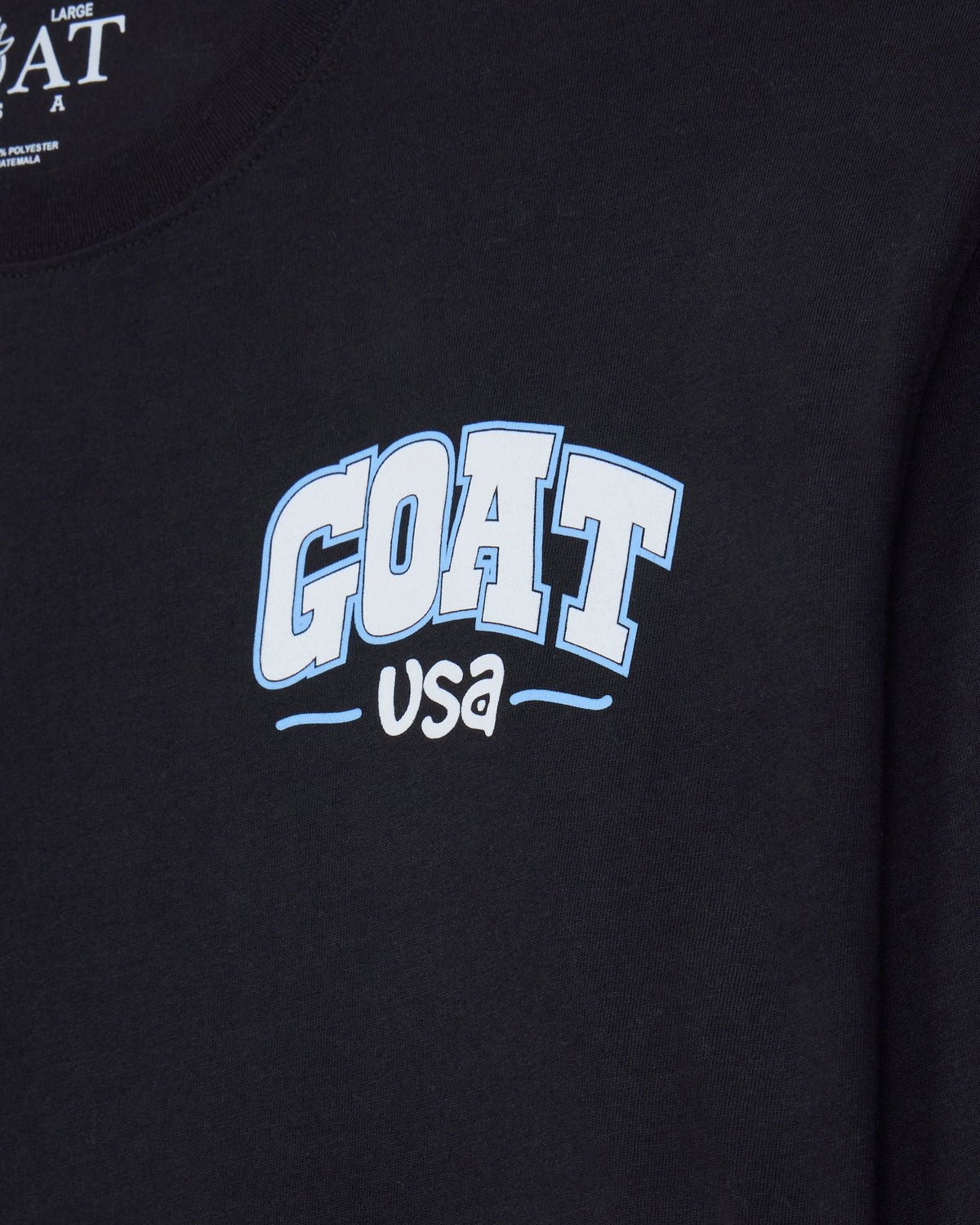 Close-up of a black long-sleeve sweatshirt featuring a light blue and white 'GOAT USA' graphic on the chest.