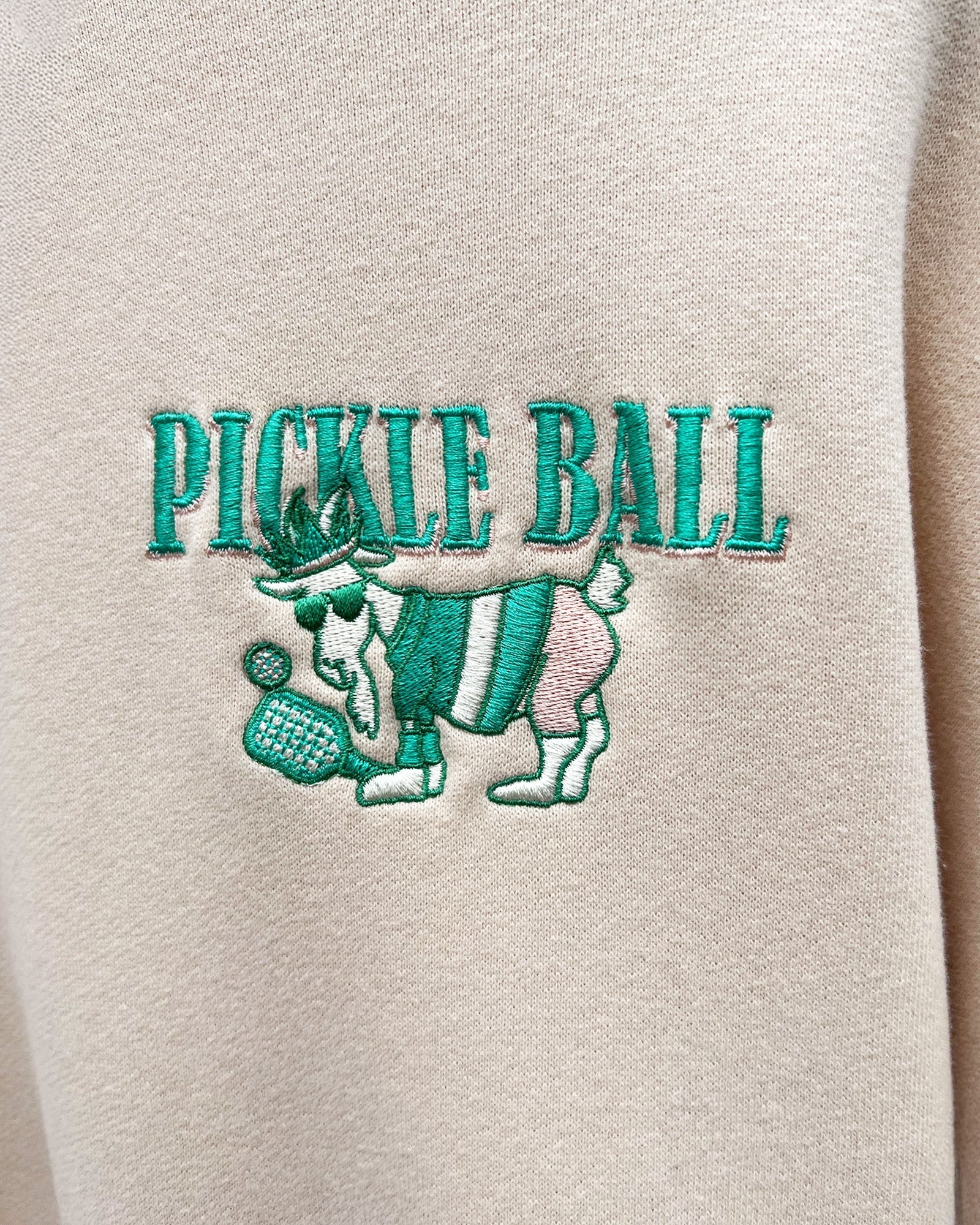 Embroidered 'Pickle Ball' design on beige fabric