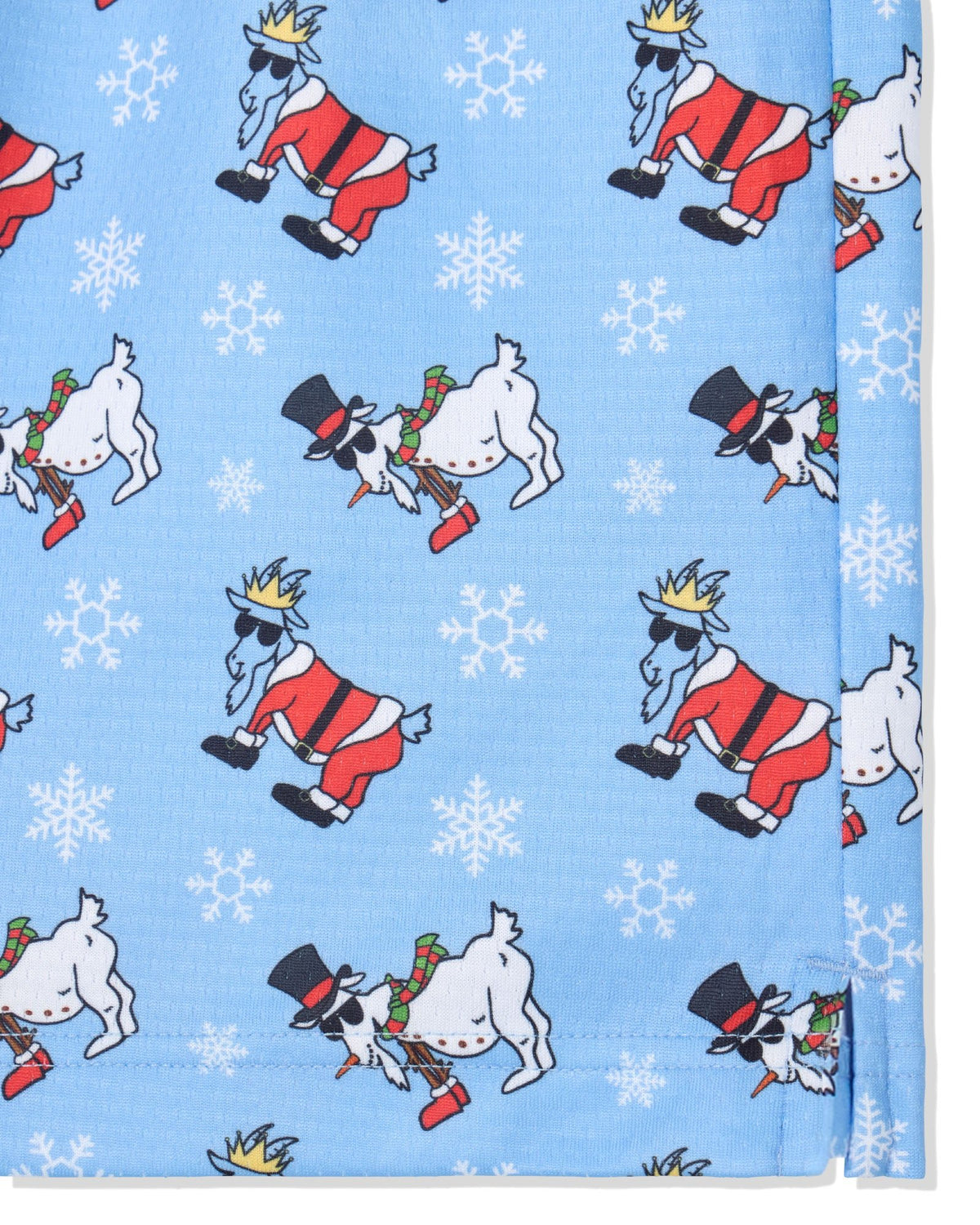 A close-up of a light blue fabric product,  featuring a repeating pattern of white goats dressed in red and black holiday clothing, some wearing gold crowns and black top hats, with white snowflakes scattered throughout.