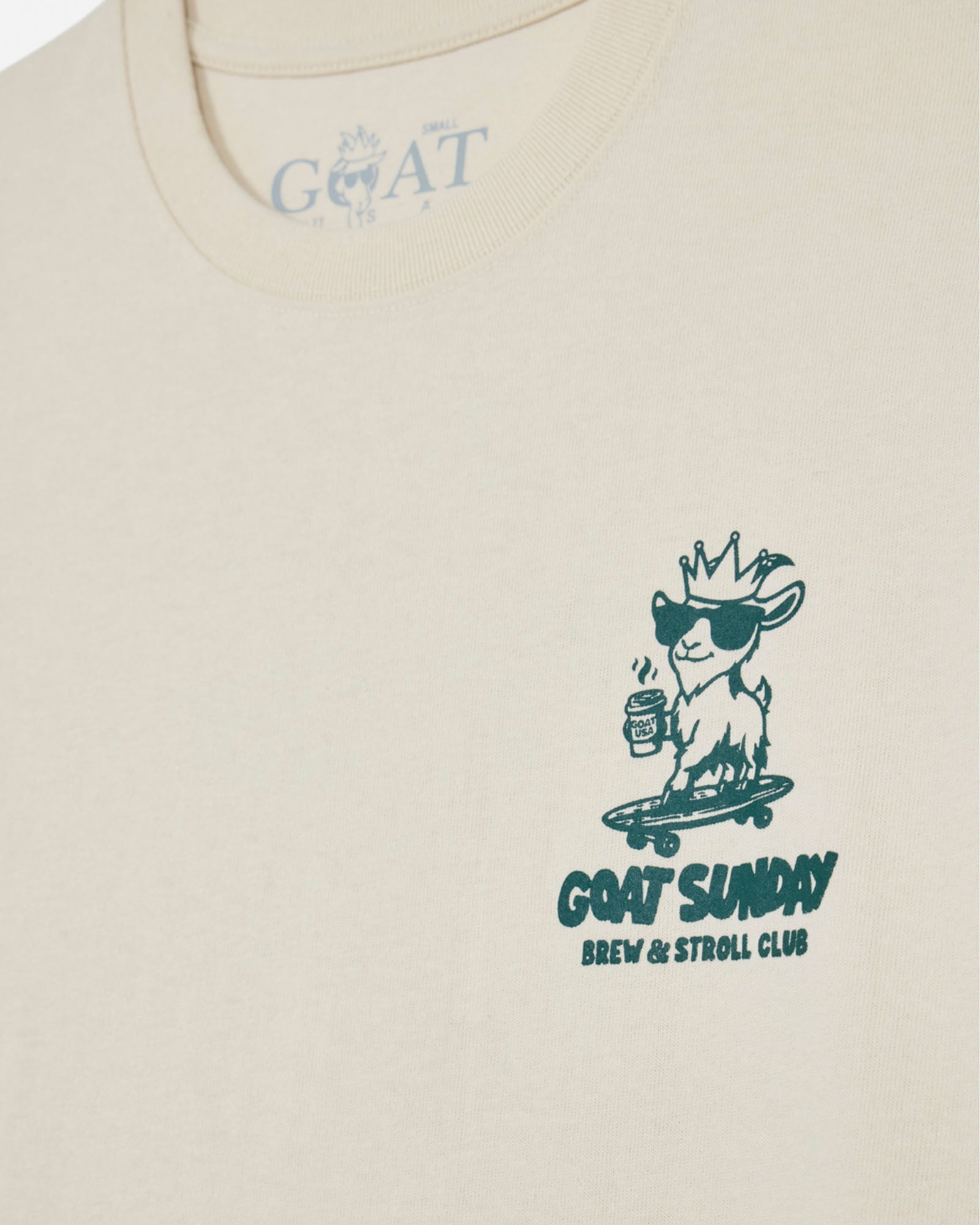Beige t-shirt with a graphic design of a goat on a skateboard and text 'GOAT SUNDAY Brew & Stroll Club' on a beige background.