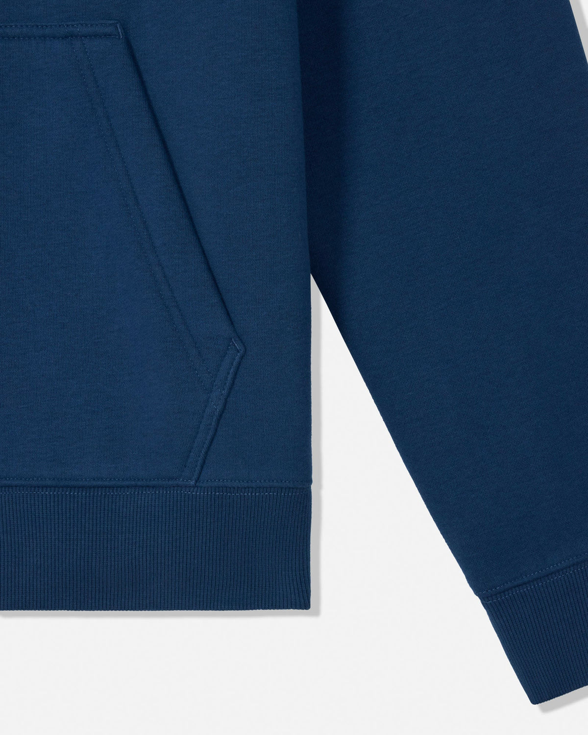 Close-up of a navy blue sweatshirt showing the sleeve, ribbed cuff, and part of the front pocket on a white background.