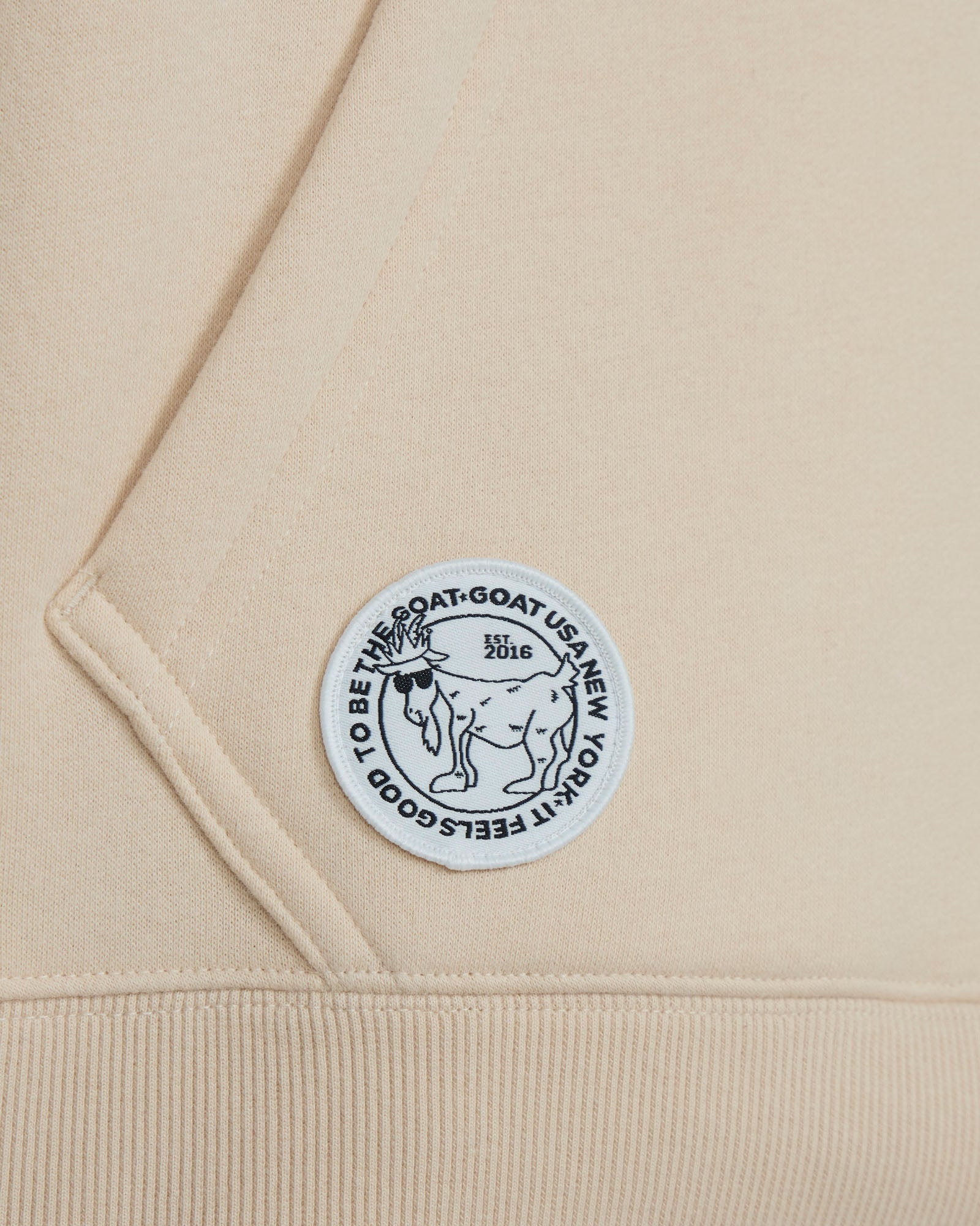 Close-up of a beige fabric with a circular logo featuring text and an illustration.