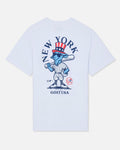 White short-sleeve t-shirt with a large graphic on the front featuring a blue cartoon goat in a baseball uniform, a red and white top hat, and the text 'NEW YORK' and 'GOAT USA'.