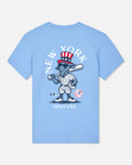 A light blue short-sleeve t-shirt with a large graphic on the front featuring a cartoon goat in a baseball uniform and top hat, with 'NEW YORK' above and 'GOAT USA' below.