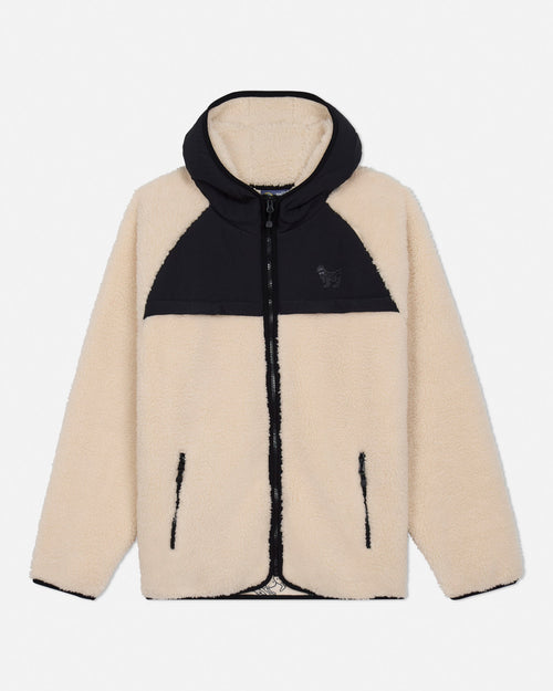 Two-tone sherpa jacket with beige front and black hood on a light gray background