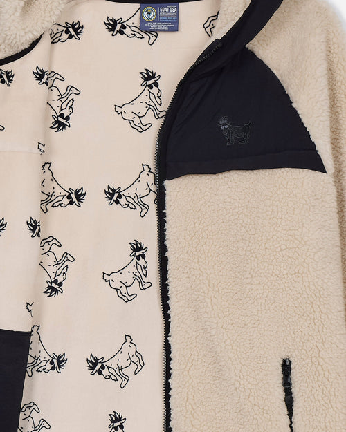 Close-up of a fleece jacket with goat pattern and visible brand label.