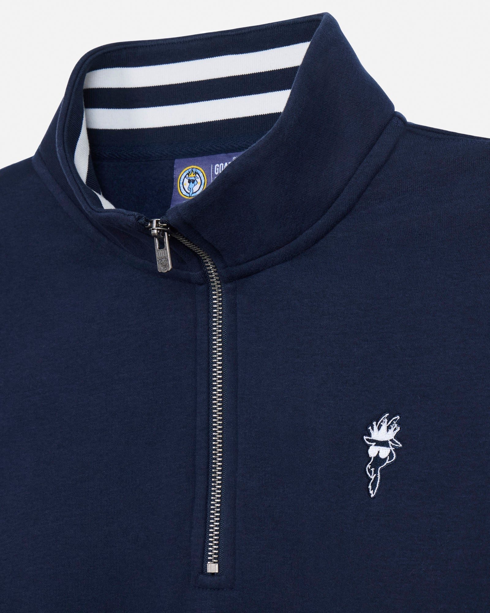 Close-up of a navy blue quarter-zip pullover with a white embroidered bird logo on the chest, a white and navy striped inner collar, and a silver zipper.#color_navy-blazer