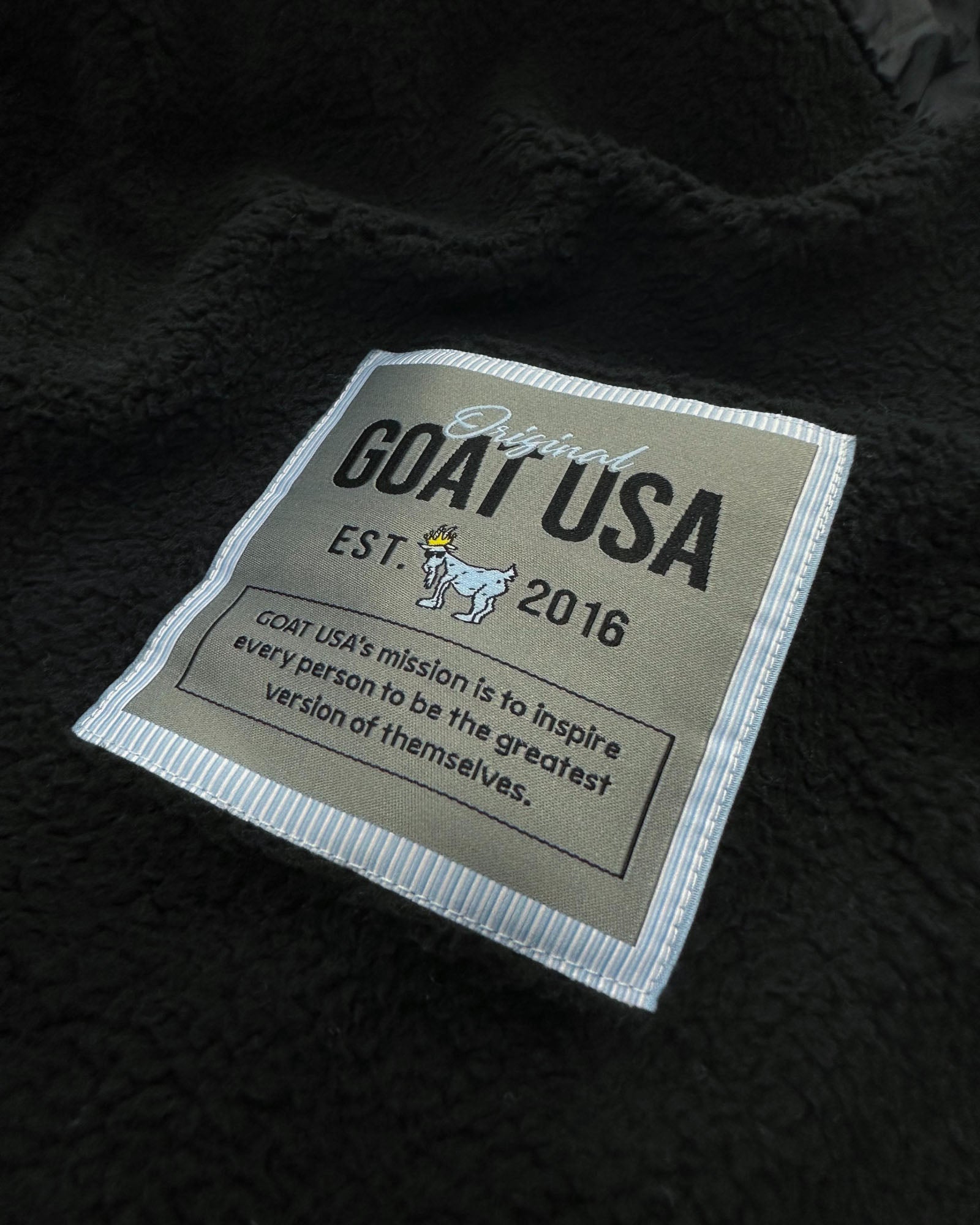 Close up of stitch tag on black Men's Puffer Fleece Vest#color_black