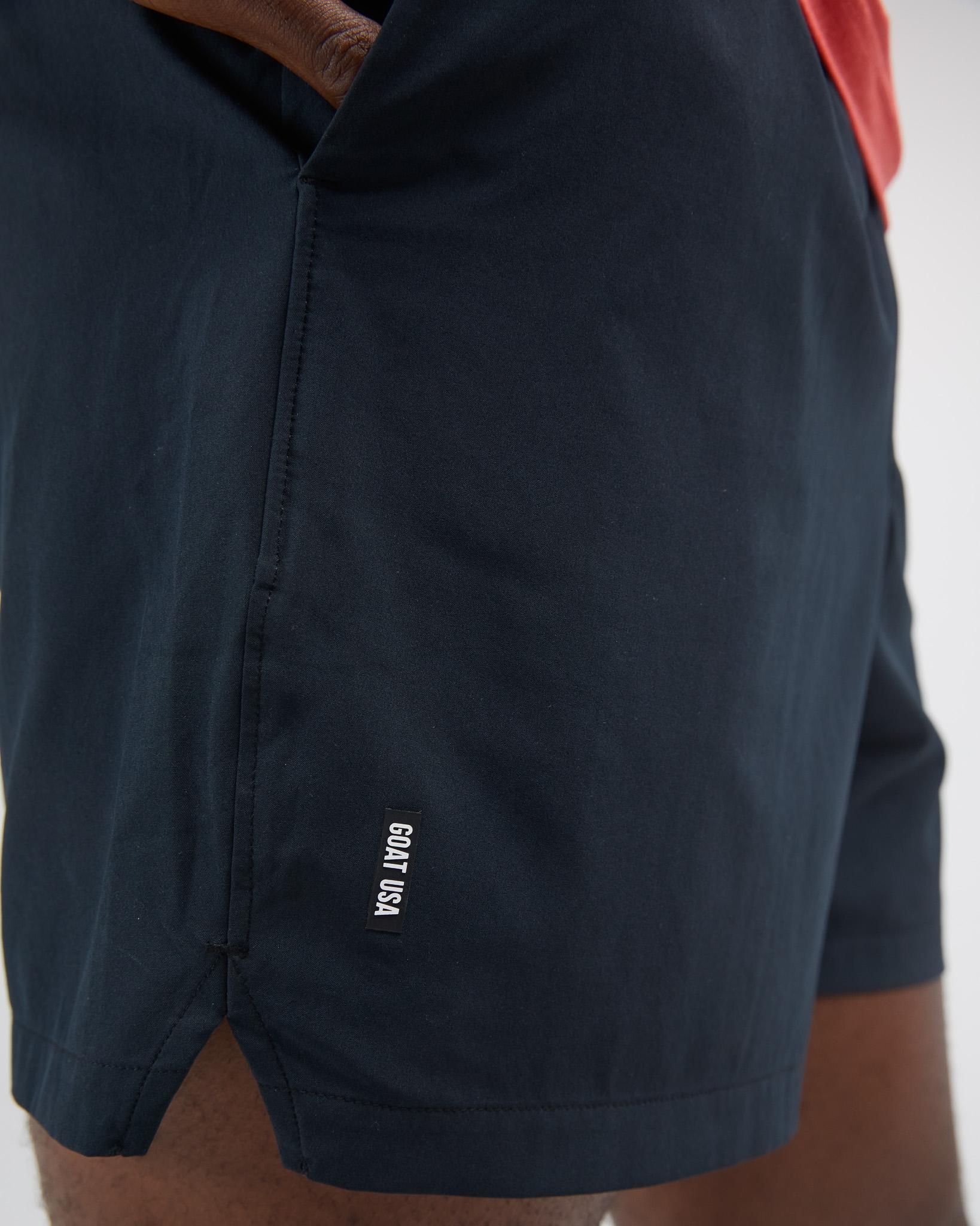 Black shorts with a brand logo on a white background#color_black