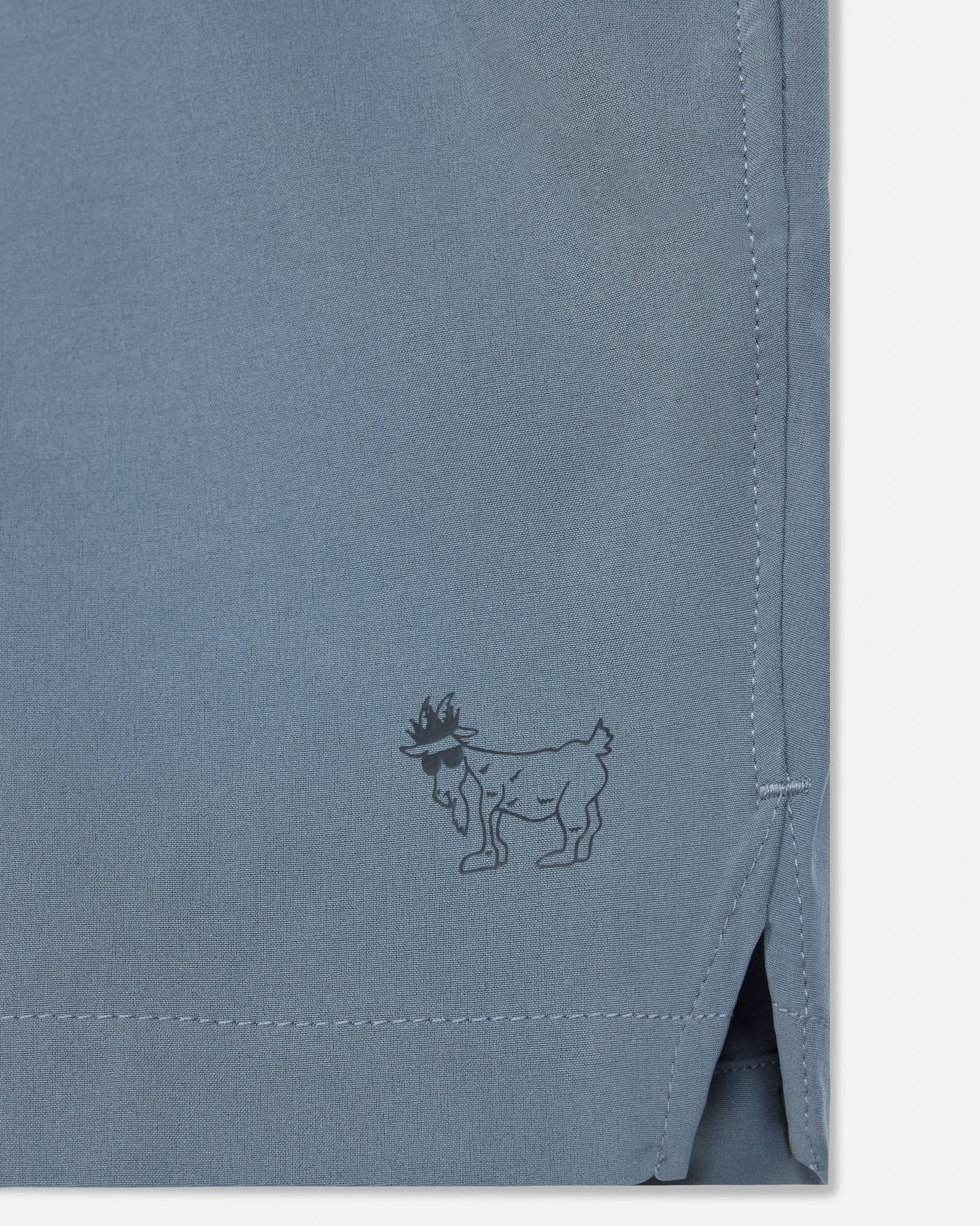 Gray fabric with a small embroidered design of a goat wearing in a crown.#color_storm-gray