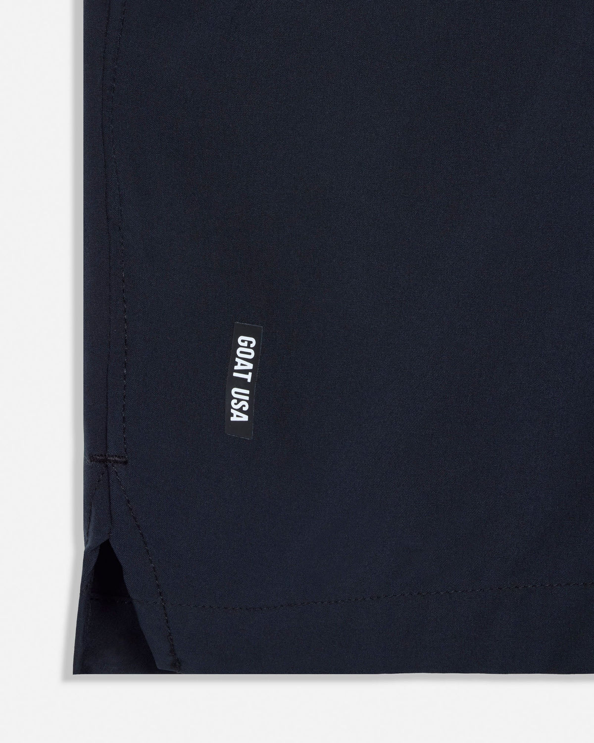 Close-up of a black garment with a small label on a white background#color_black