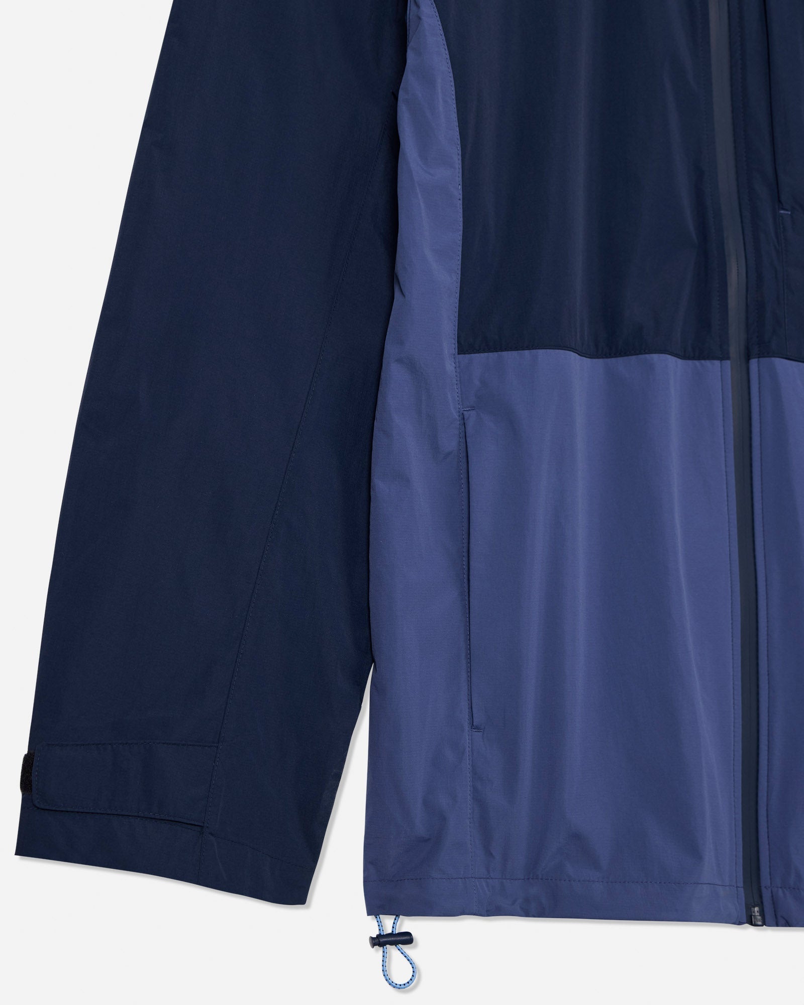 Close-up of the sleeve and pocket of navy windbreaker