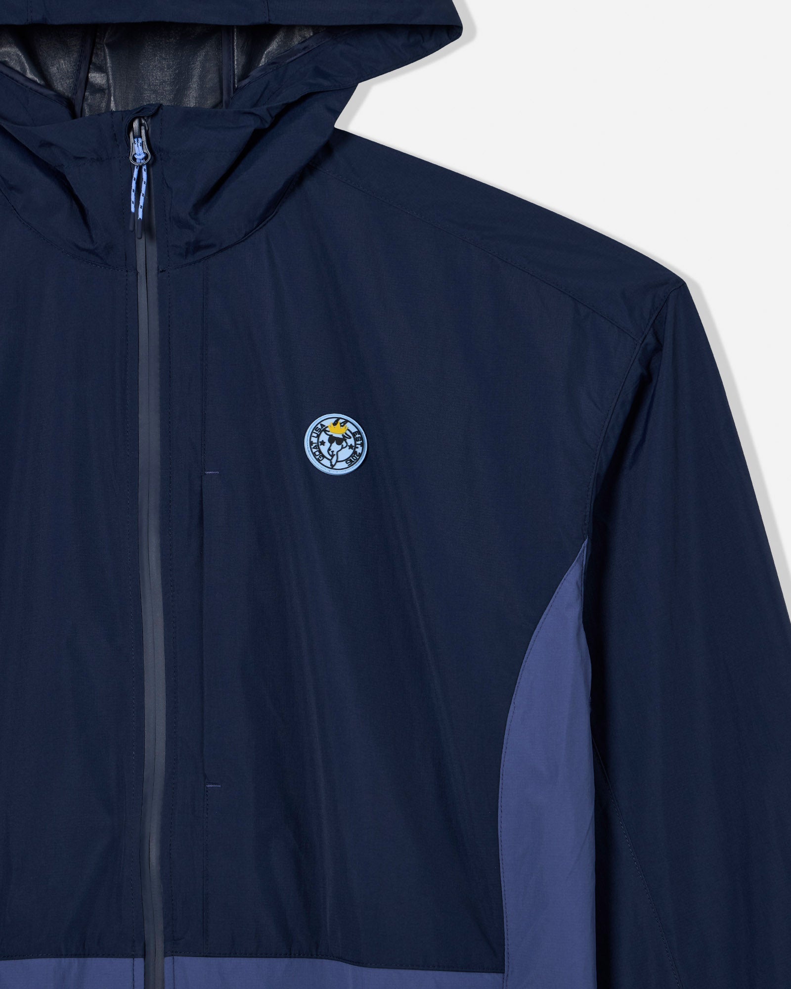 Close-up of rubber patch and zipper on navy windbreaker
