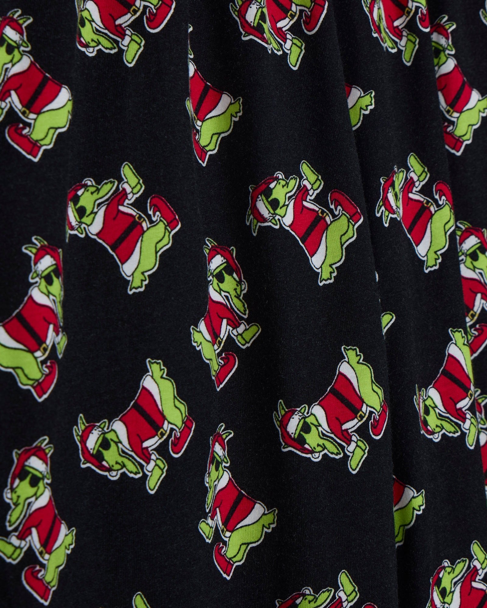 Pattern of a green creature in a red Santa suit on a black background