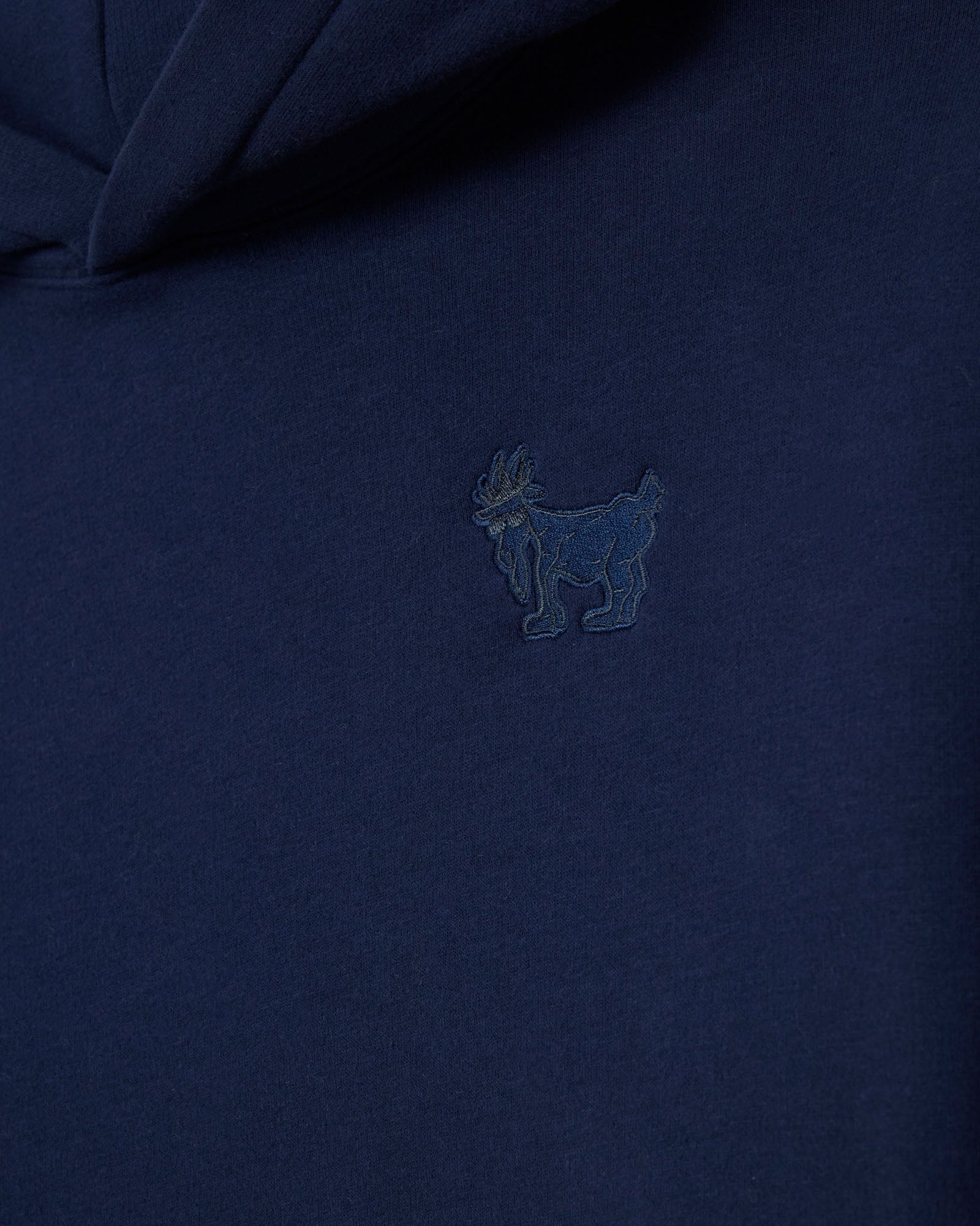 Navy blue polo shirt with a small embroidered logo on the chest.#color_navy-blazer
