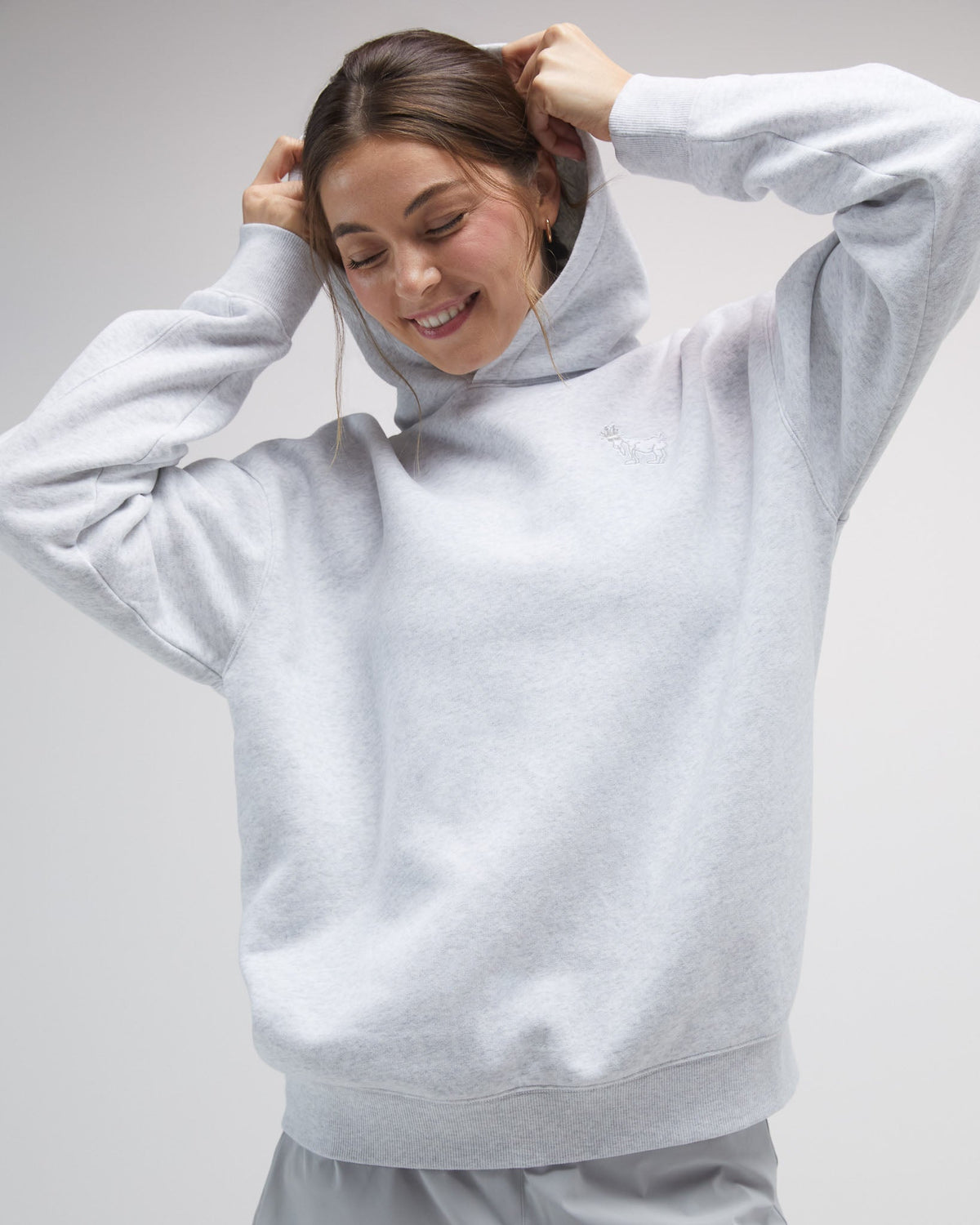Person wearing a light gray hoodie on a plain background