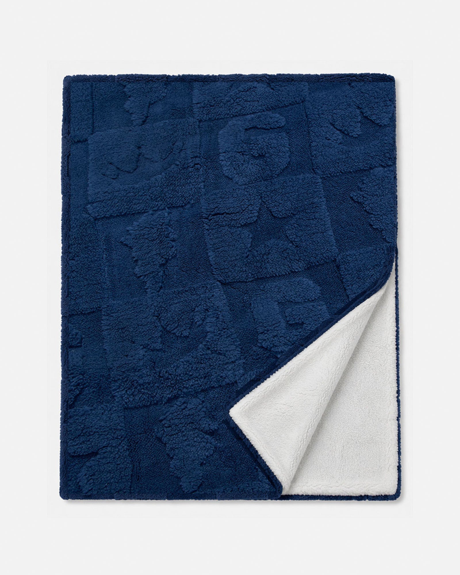 A navy blue textured throw blanket with a white sherpa lining, shown folded to display both sides against a light gray background.