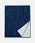 A navy blue textured throw blanket with a white sherpa lining, shown folded to display both sides against a light gray background.