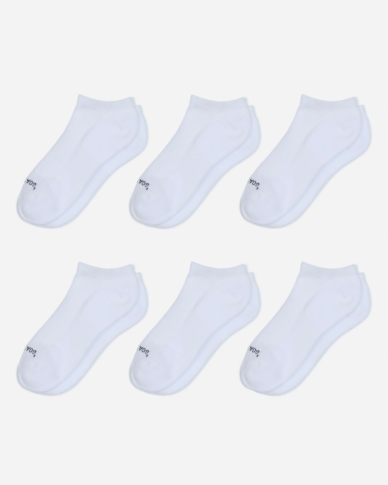 Set of six white ankle socks on a light gray background