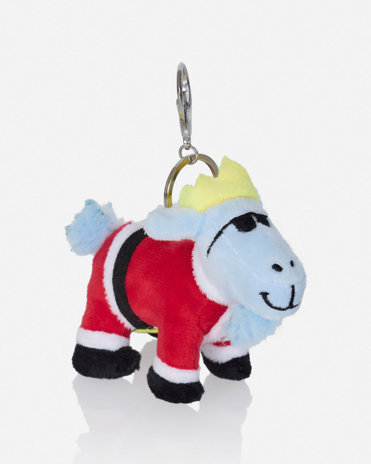 A plush goat keychain accessory dressed in a Santa-style red outfit with black and white trim, a light blue face and tail, a yellow crown, and a silver metal key ring on a clean white background.