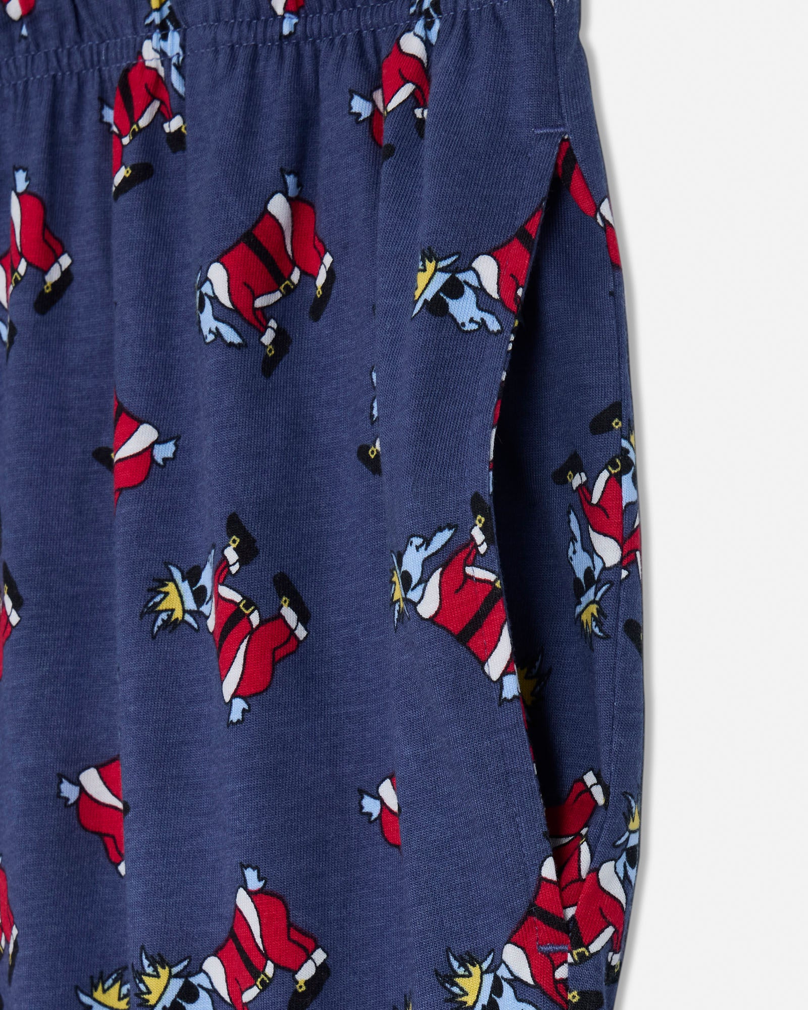 Navy blue pajama pants with cartoon character pattern on a light gray background