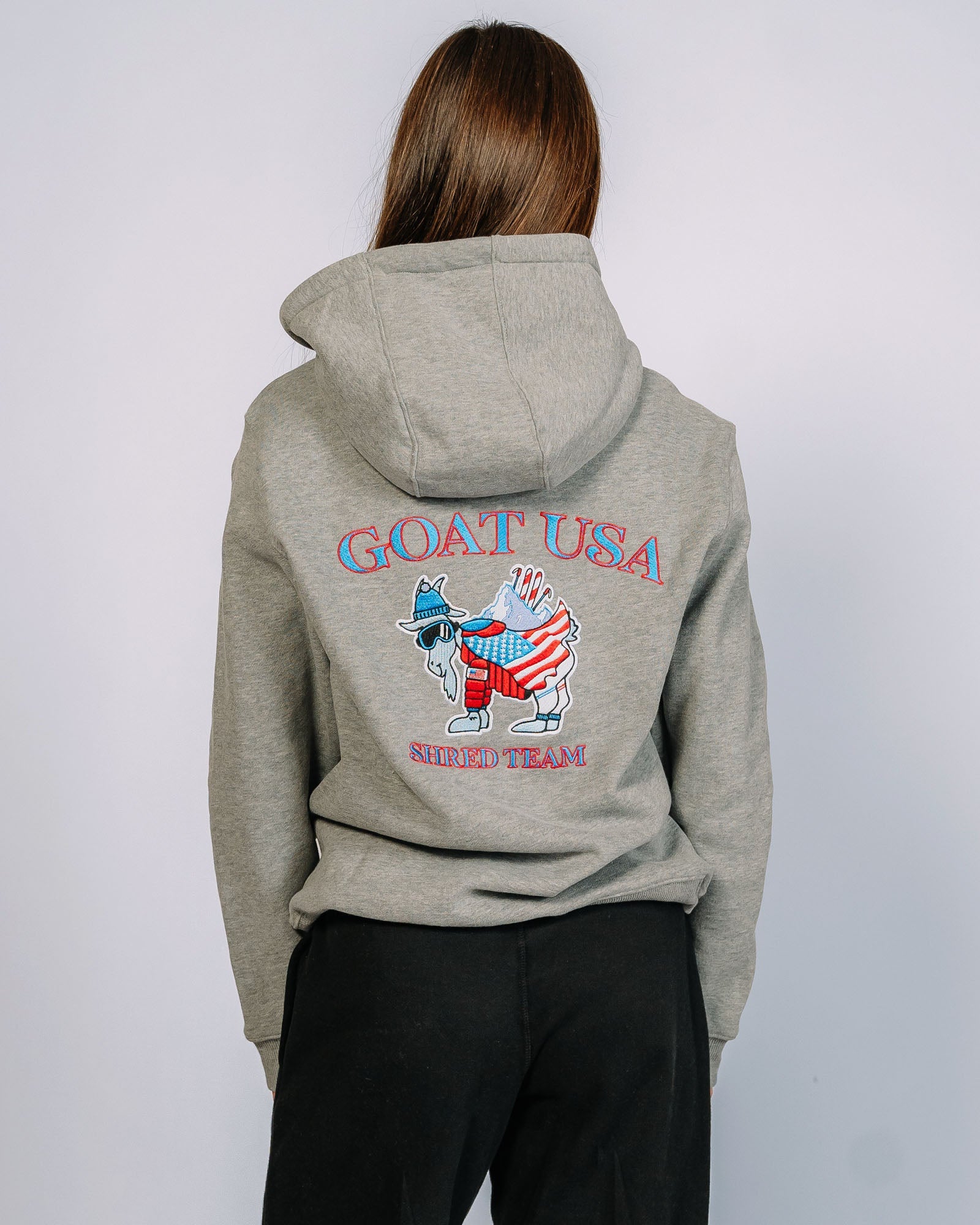 Back of gray hoodie with a goat dressed in American themed winter attire and mountains plus skis